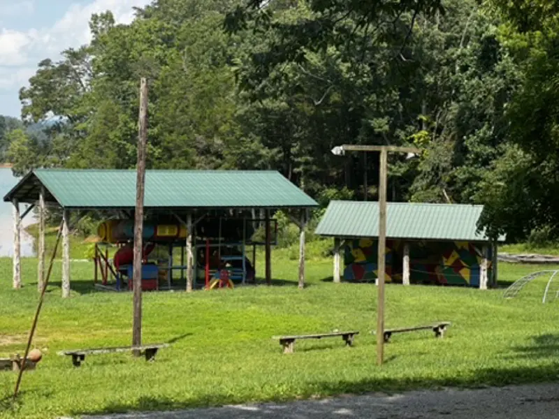 Two green-roofed picnic shelters under the trees