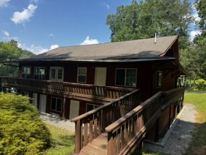 Two-story wooden lodge with a wraparound deck